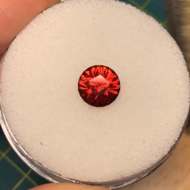 A red and orange faceted garnet.